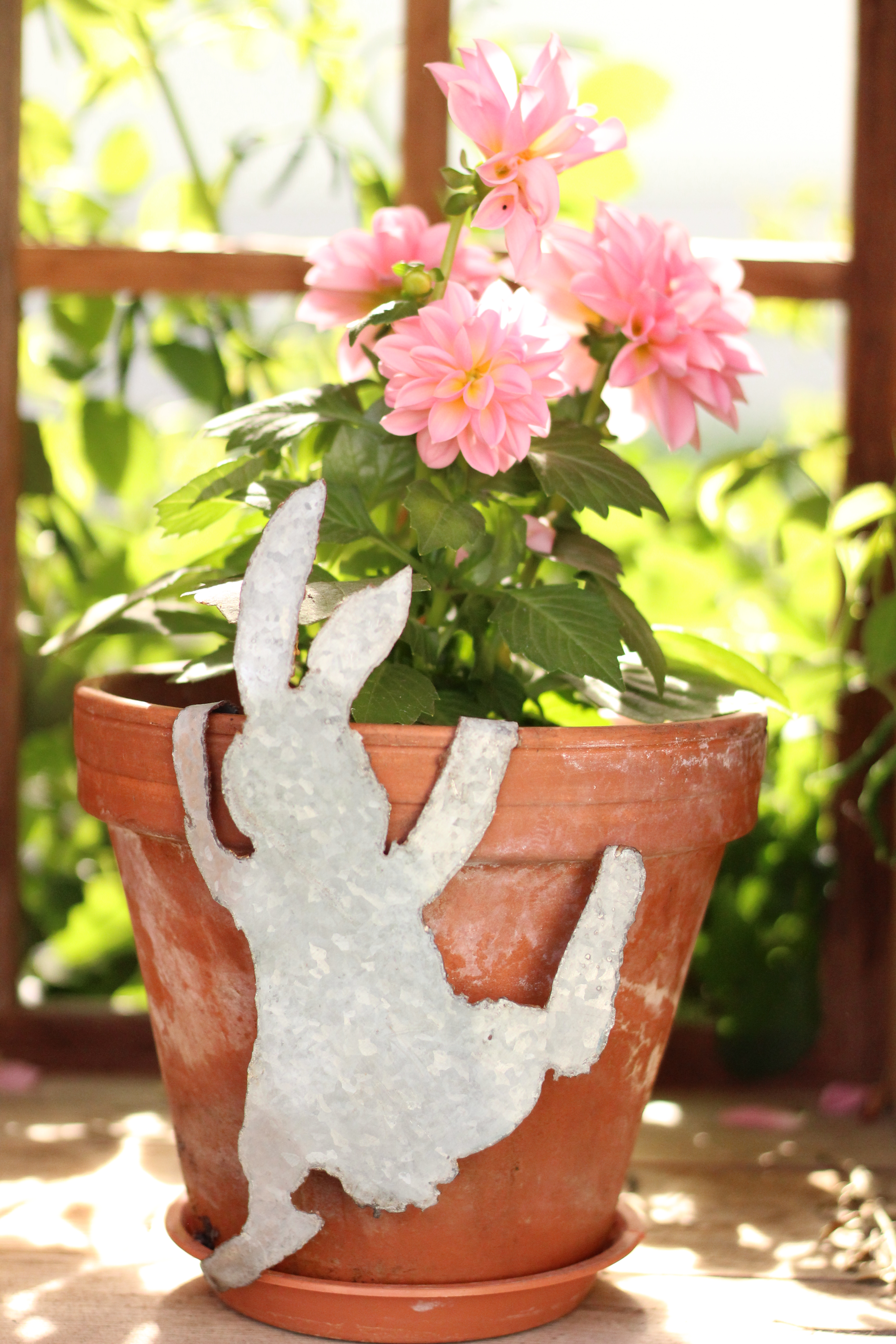 Haus aus Metall am Blumentopf hängend